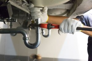 plumber fixing a pipe under sink